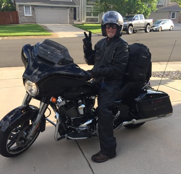 Middle aged man sits atop a Harley Davidson 