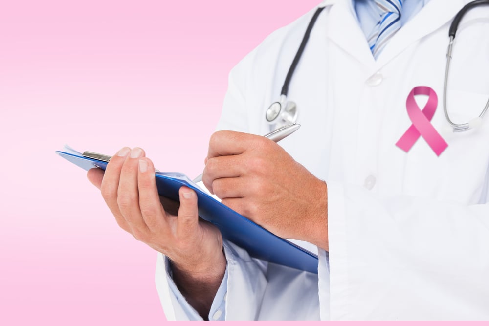 Doctor writing on clipboard against pink