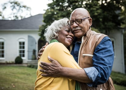 Пожилые люди обнимаются после преодоления чувства вины за выживание после рака