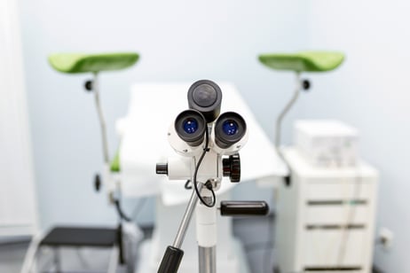 Empty gynecology office with modern colposcope and medical tools