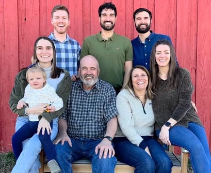 Superviviente de cáncer de colon con su familia frente al granero