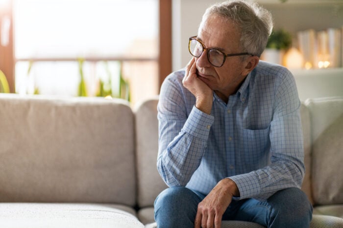 Man sitting on couch thinking