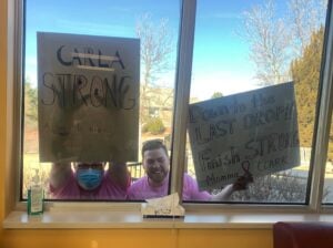 Carla’s family celebrating her final chemotherapy treatment with signs outside due to COVID restrictions