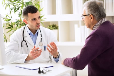 Doctor masculino hablando con un paciente masculino mayor