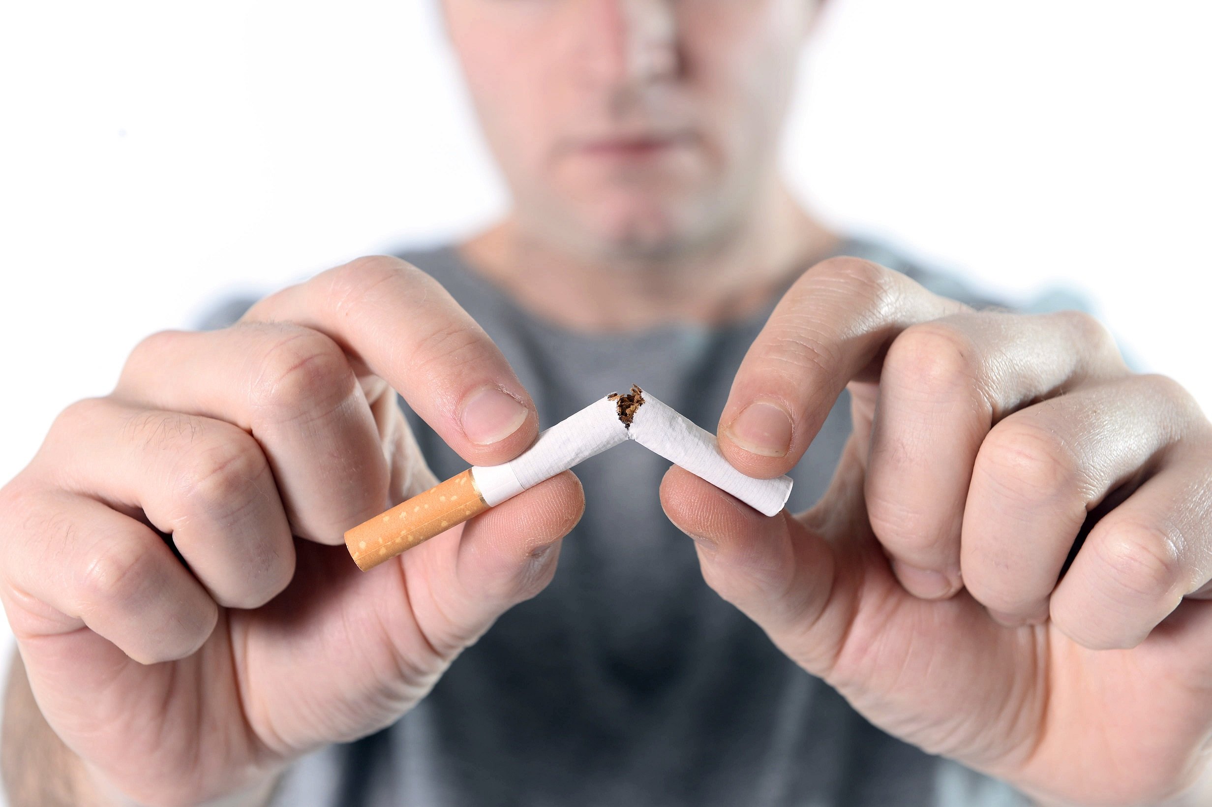 Man breaking a cigarette in half