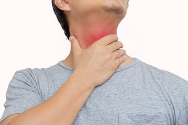 A man touches his throat, which is colored red