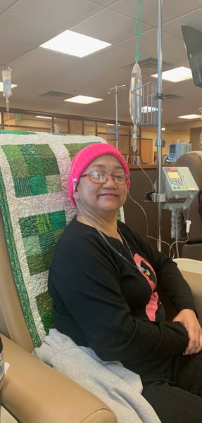 Breast cancer survivor wears pink hat while getting chemotherapy that was part of successful breast cancer treatment