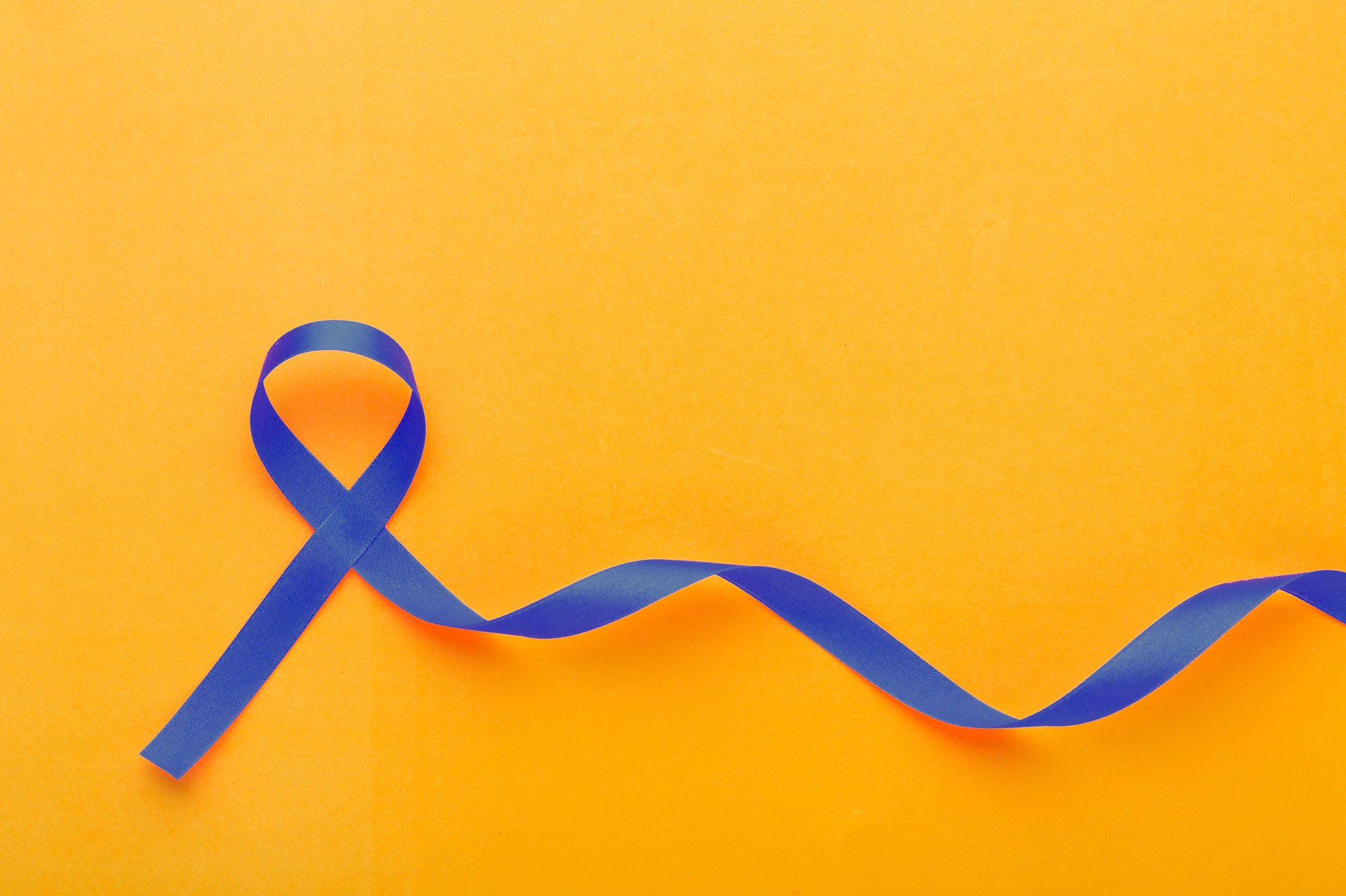 Un trozo de cinta azul doblado sobre sí mismo sobre fondo amarillo