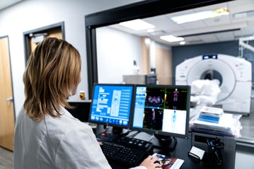 Radiologist Monitors Results While Patient Undergoes CT Scan Procedure