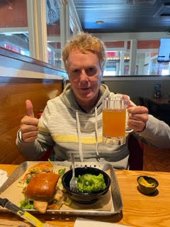 Scott Richardson con el pelo rizado tras el tratamiento del cáncer disfrutando de una bebida y una comida