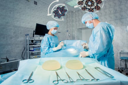 Team of surgeons working on patient in surgical operating room
