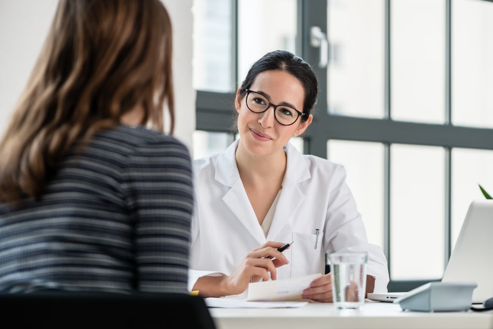 physician in office speaking with patient about prognosis