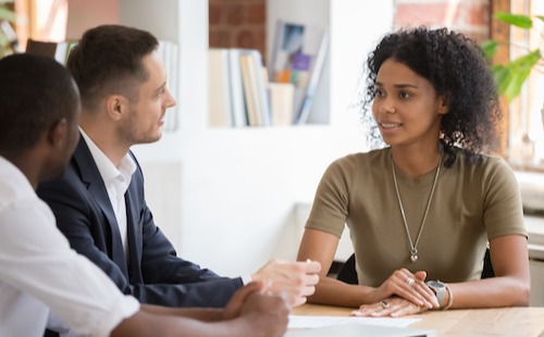 financial advisor speaking with clients at a table