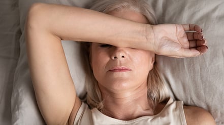 Woman holding hand over face feeling fatigued